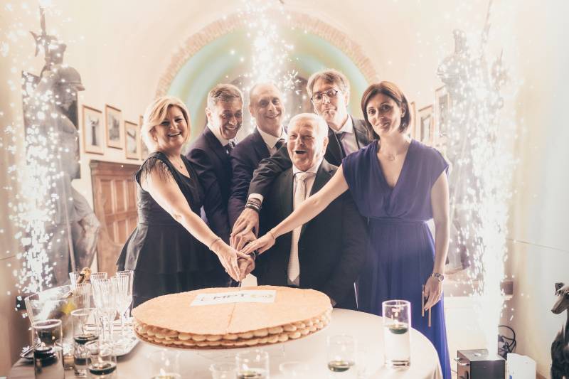 Company owner and staff cutting the cake during a corporate celebration