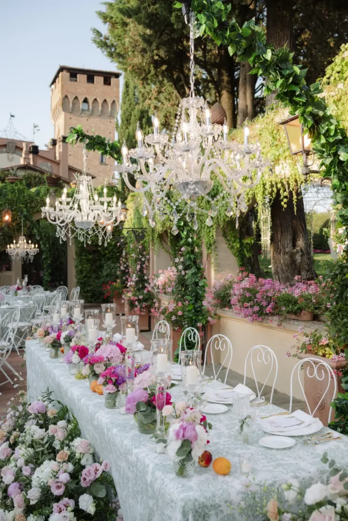 Elegant outdoor wedding reception table with chandeliers in Tuscany
